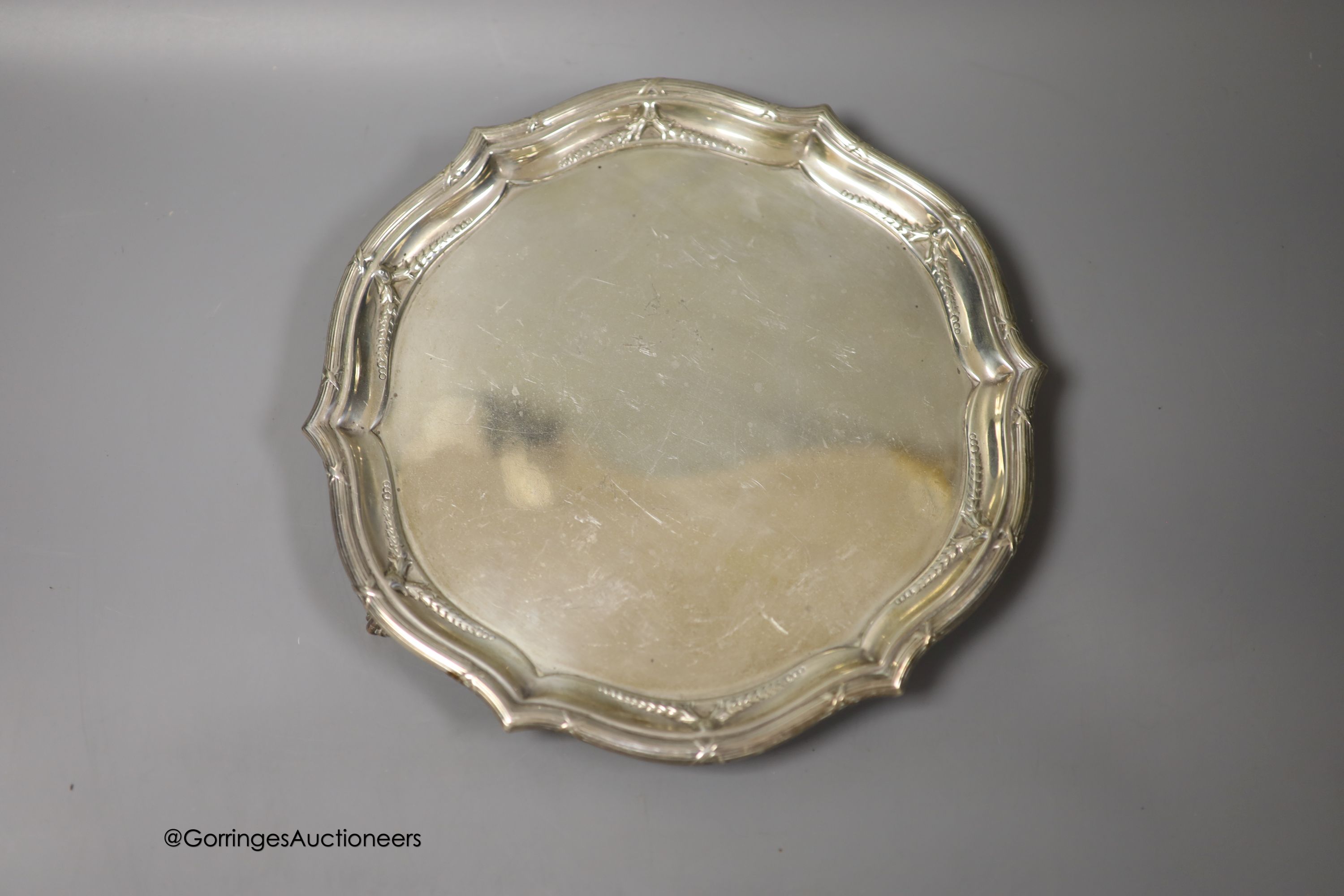 An Edwardian silver shaped circular salver, Goldsmiths & Silversmiths Co Ltd, London, 1902, 25cm and three silver napkin rings